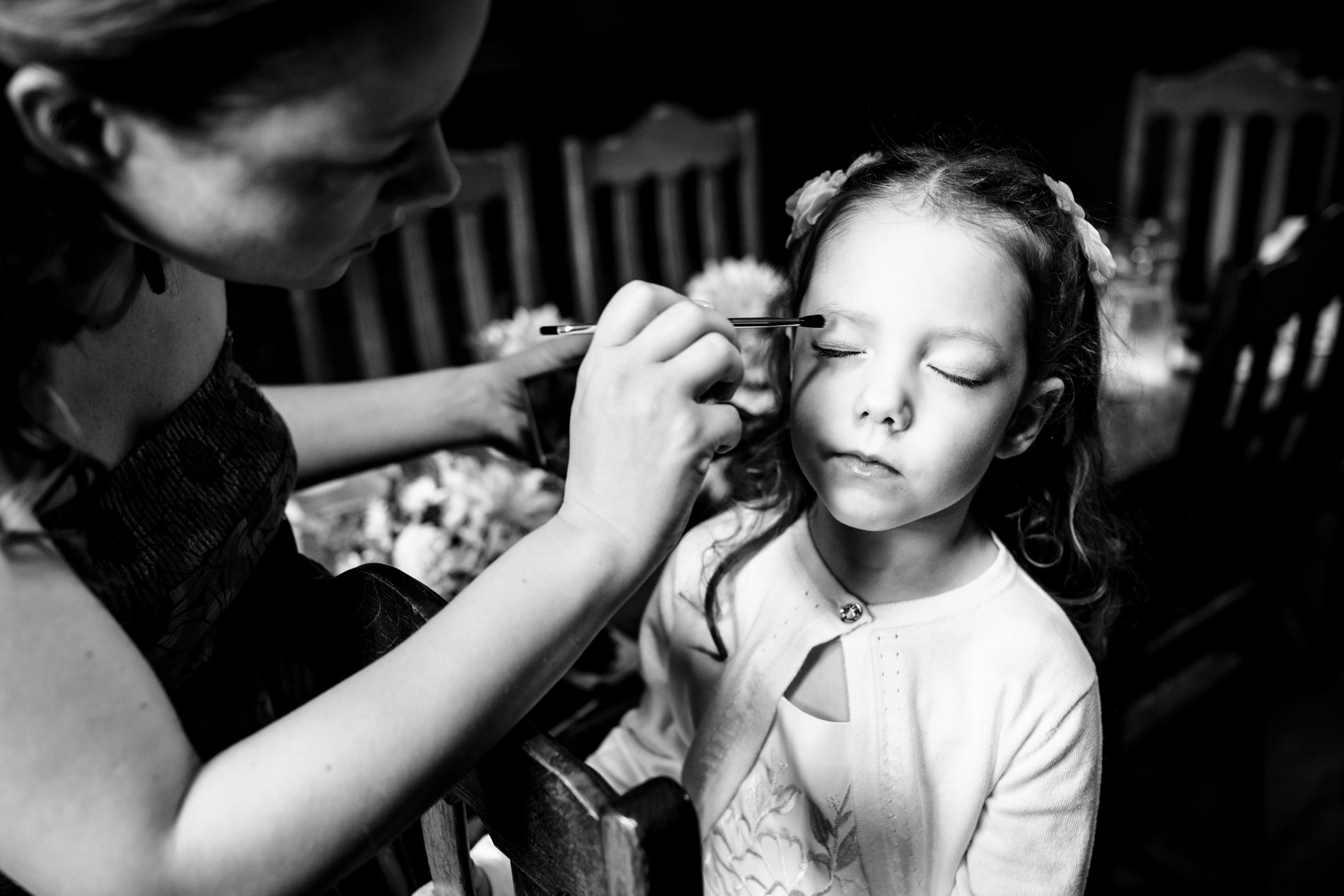 Bride puts makeup on flower girl