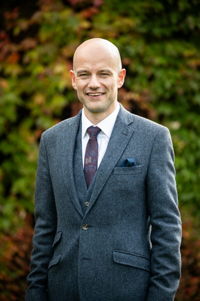 Portrait of groom in front of autumnal leaves