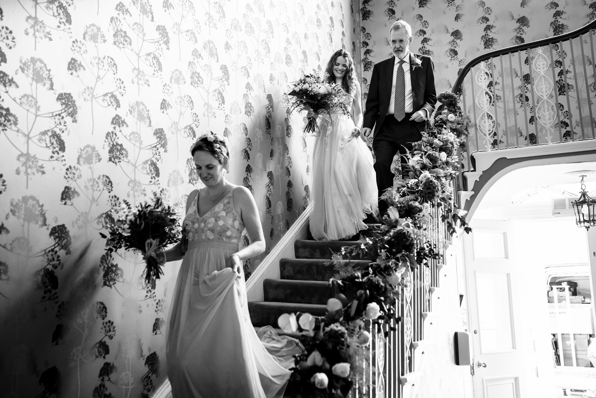 Bride and father walk down staircase at St Michael's Manor Hotel