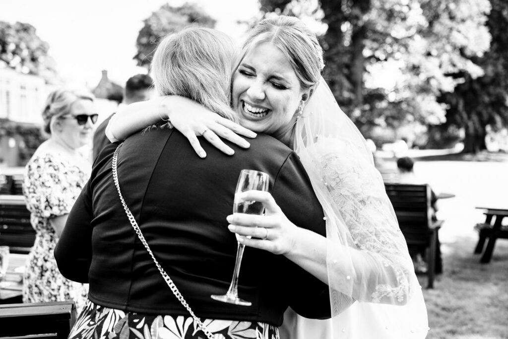 Bride laughs while hugging Mum after getting married