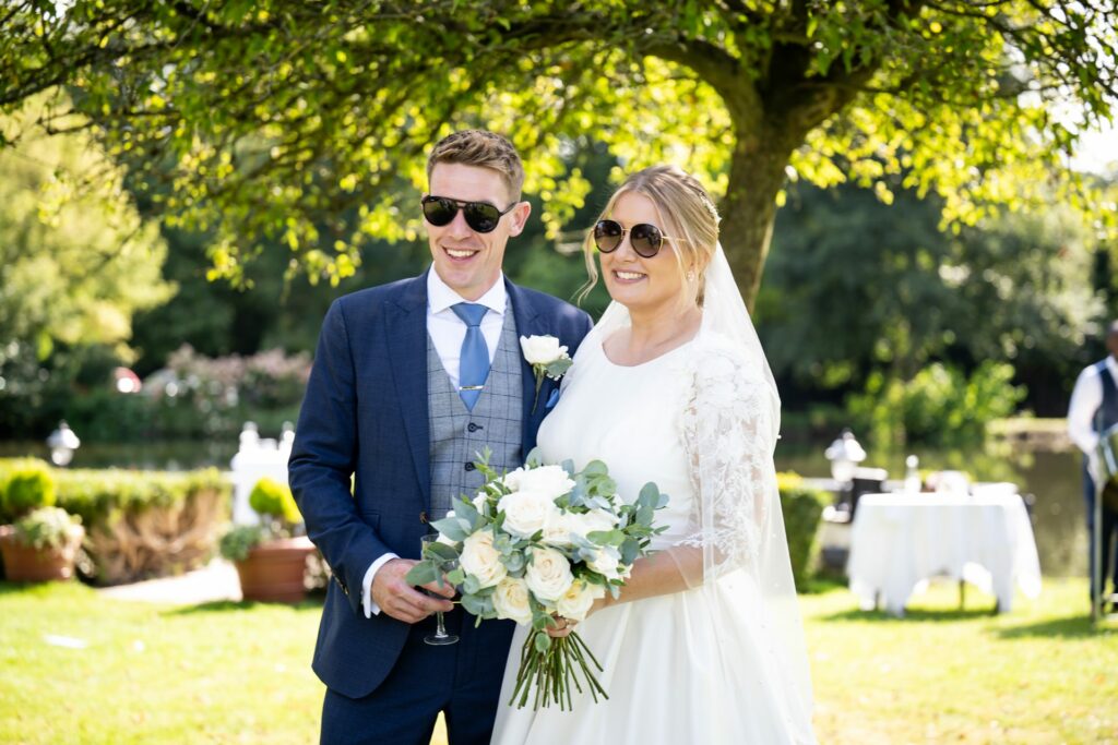 Bride and groom wear sunglasses on St Michaels Manor lawn