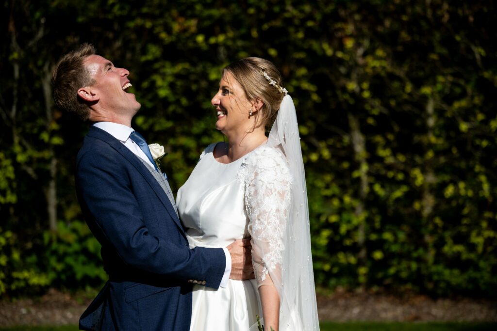 Groom laughs at bride during St Michaels Manor wedding portraits