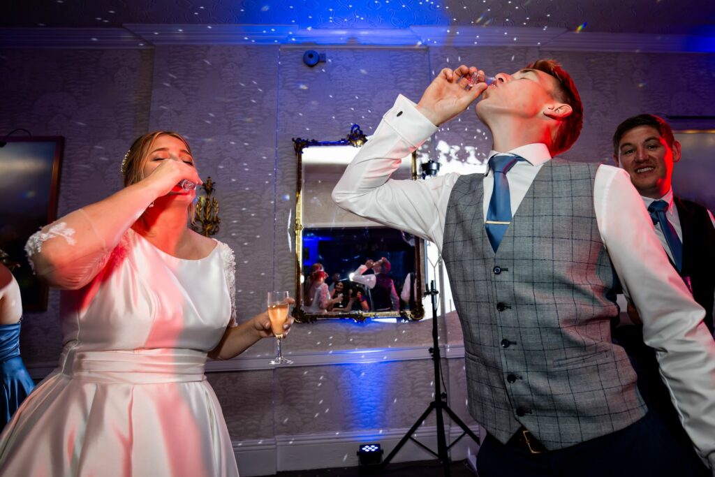 Bride and groom do shots on the dance floor at St Michaels Manor
