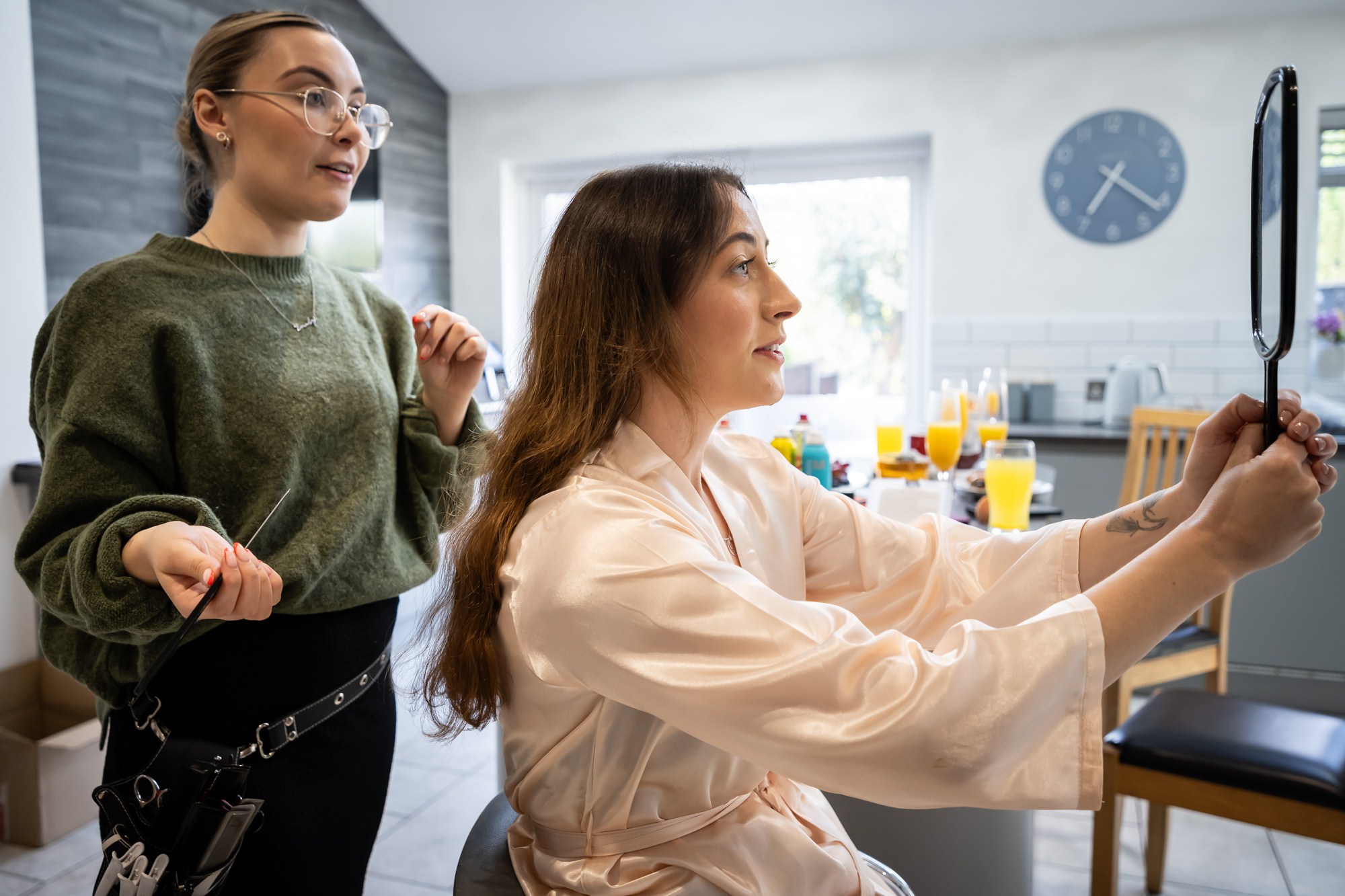 Bridesmaid looks in mirror while getting hair done