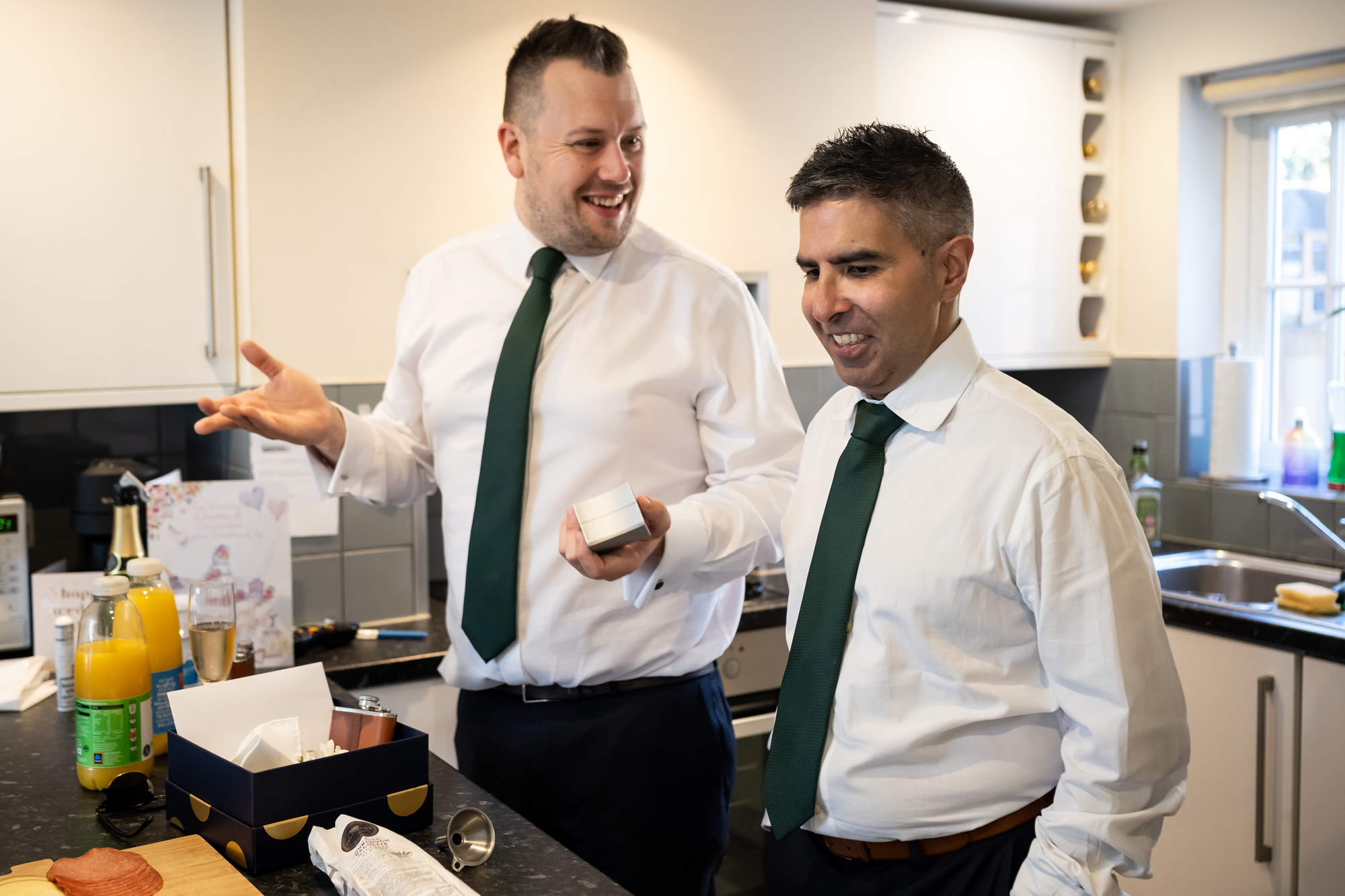 Groom and best man chat in kitchen on morning of St Albans wedding