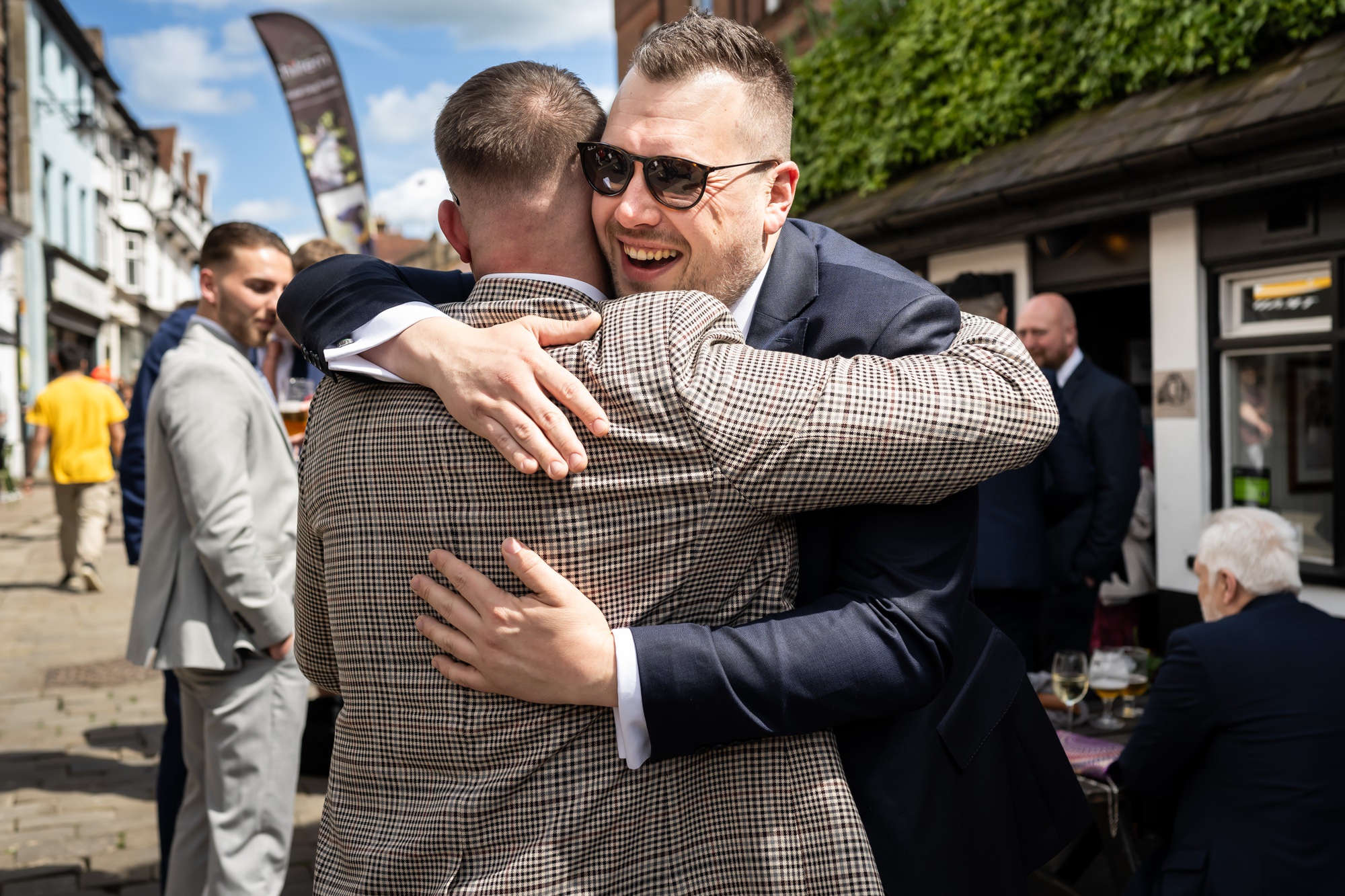 Groom hugs friend at pre ceremony pub drinks in St Albans