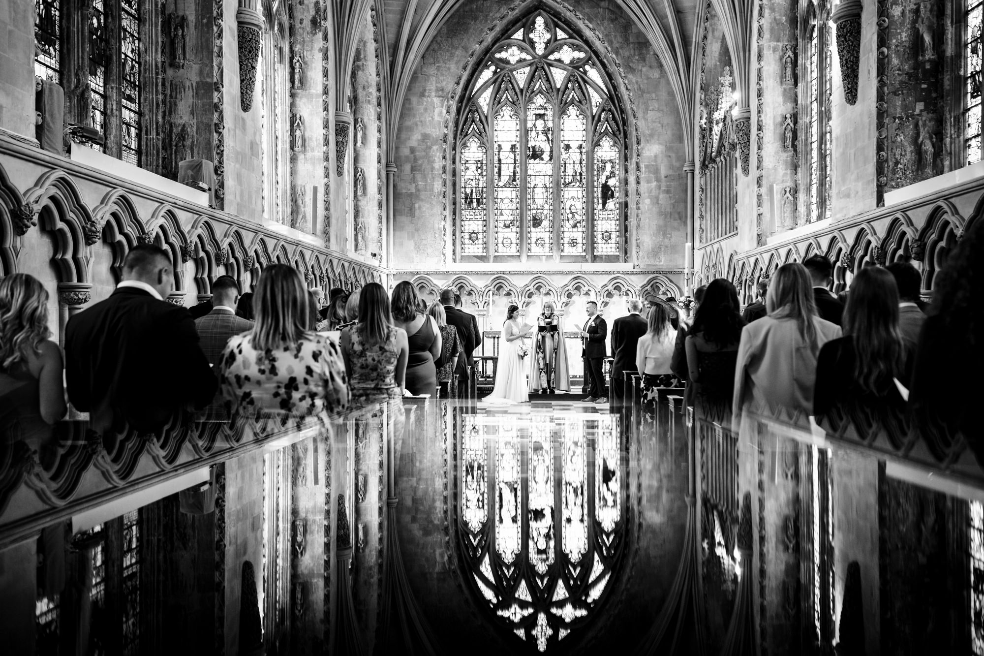Wedding ceremony at st albans cathedral with reflection of stained glass windows in floor