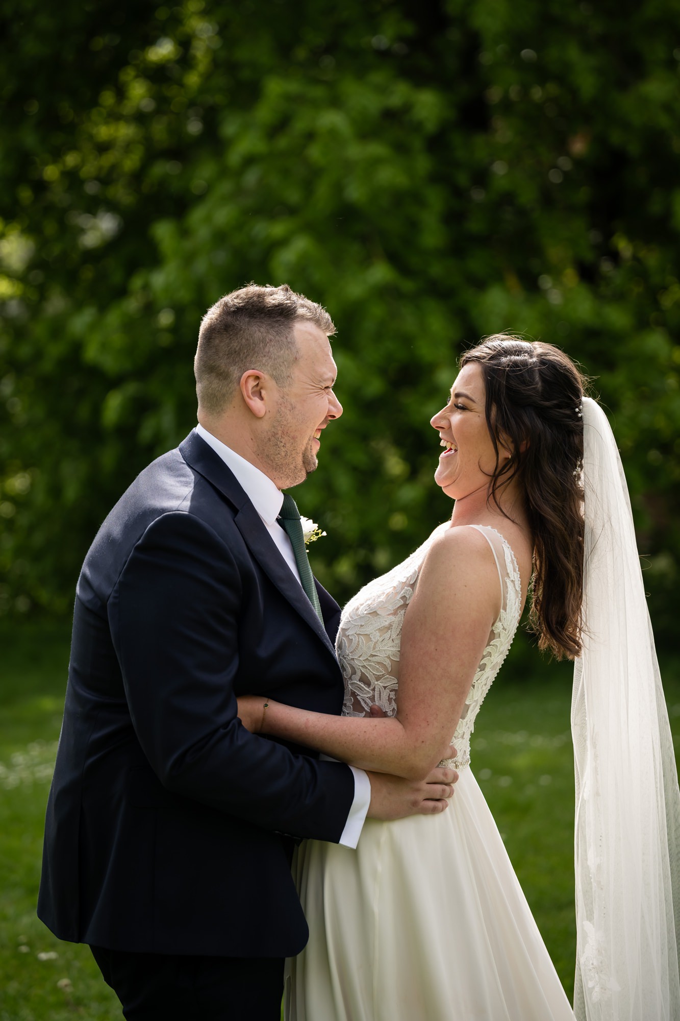 Bride and groom laugh in Verulamium Park after St Albans Cathedral wedding ceremony