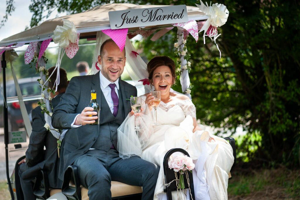 Bride and Groom travel to wedding reception from church in golf buggy