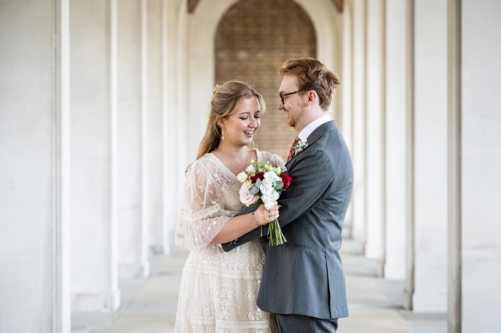Bride and groom pose in Hertford Register Office white arches