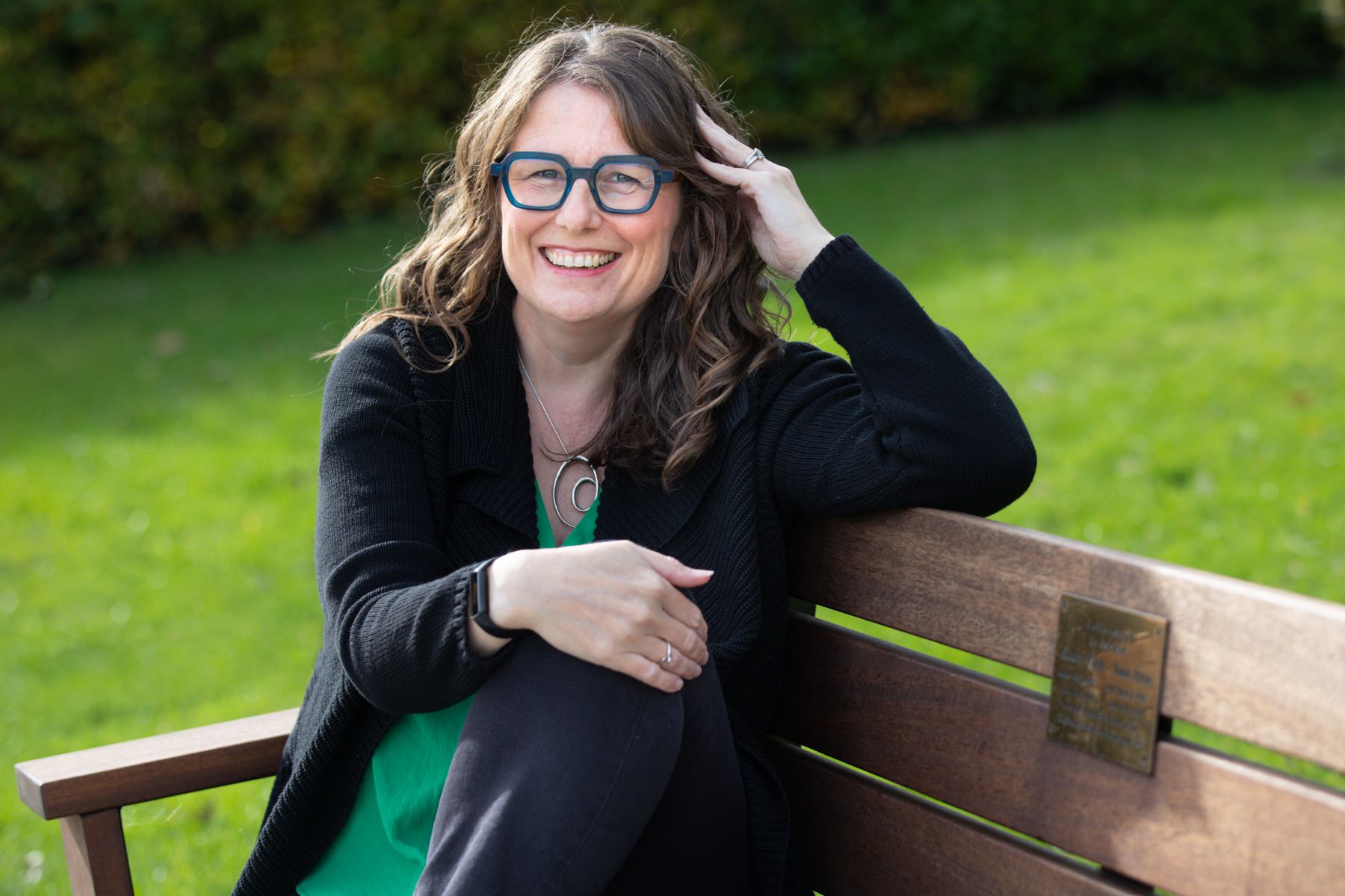 Headshot of Tori Deslauriers Hertfordshire photographer laughing on bench