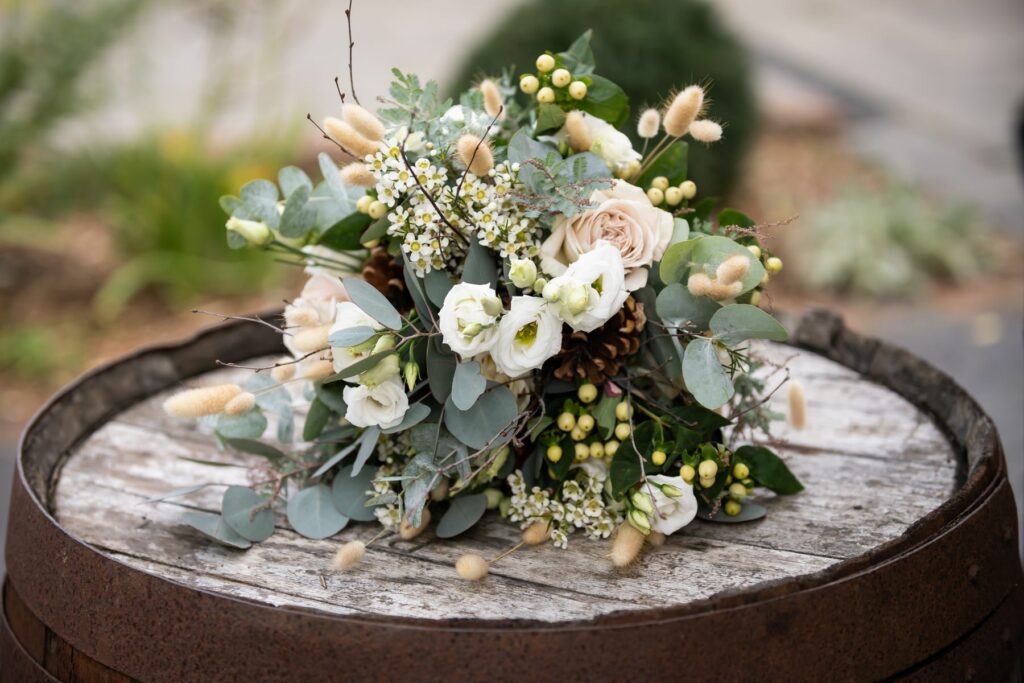 Bride's bouquet on barrel at Coltsfoot wedding venue Hertfordshire