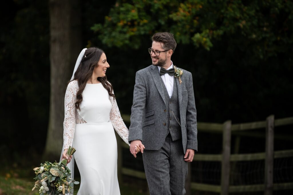 Bride and groom walk down the road in front of Coltsfoot wedding venue Hertfordshire