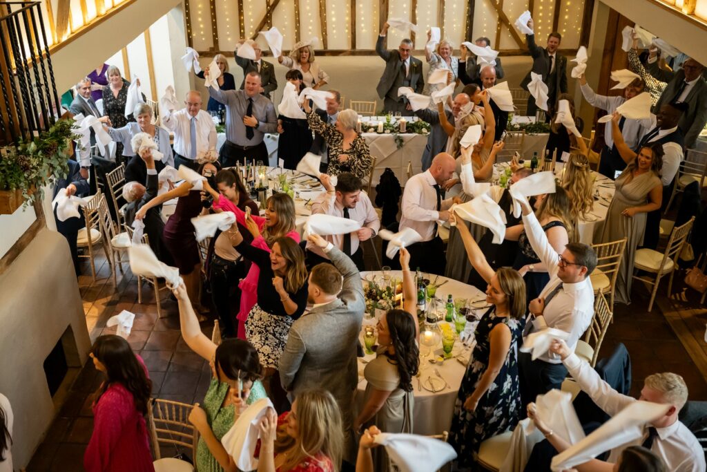 Guests wave napkins on couple's entry to Coltsfoot wedding venue Hertfordshire