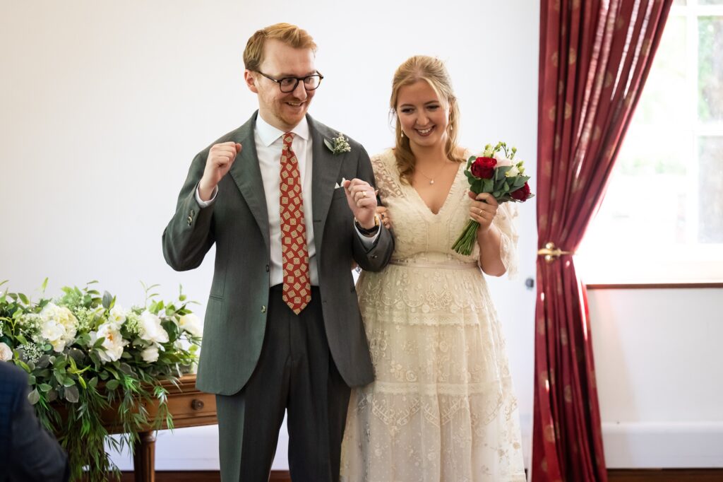 Groom cheers at being pronounced married during Hertford Register office intimate wedding