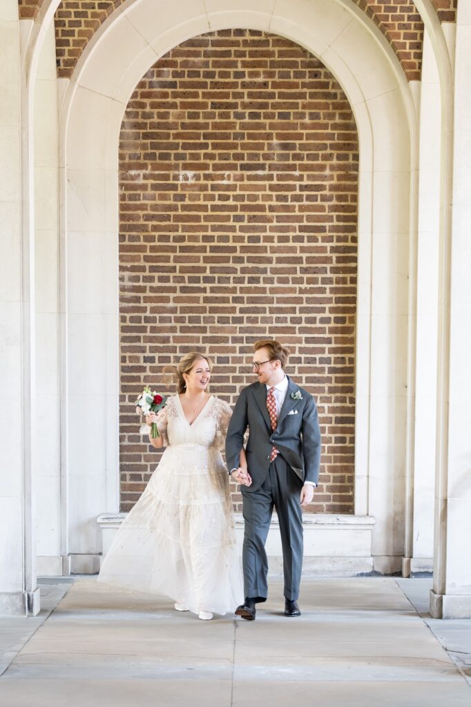 Bride and groom walk through Hertford Register office white arches