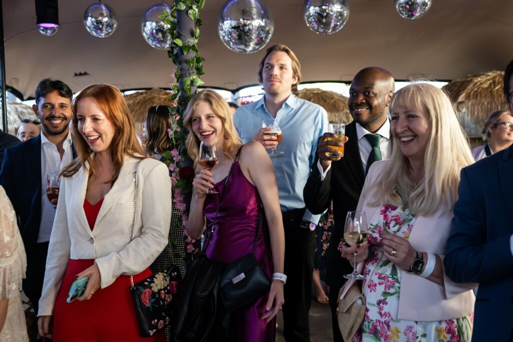 Guests laugh during relaxed standing speeches at relaxed pub wedding reception