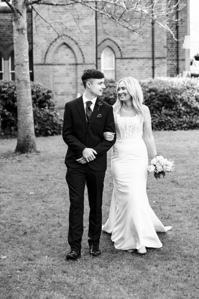 Bride and groom walk through St Albans Registry Office garden after intimate wedding ceremony with close family and friends