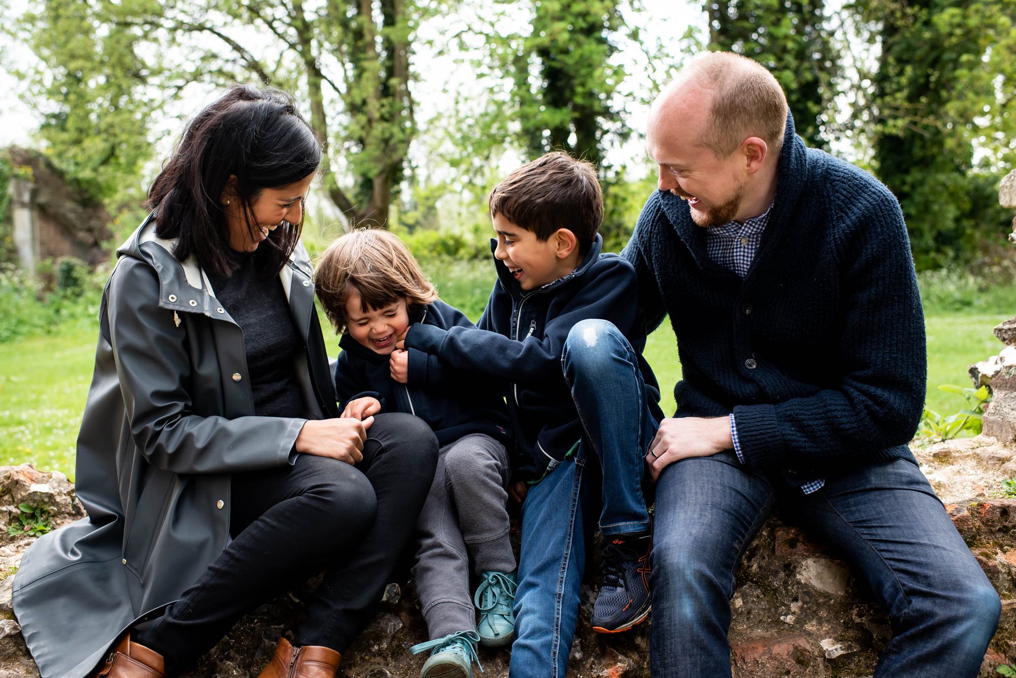 Family sit and tickle each other at Sopwell Nunnery during family photos in St Albans