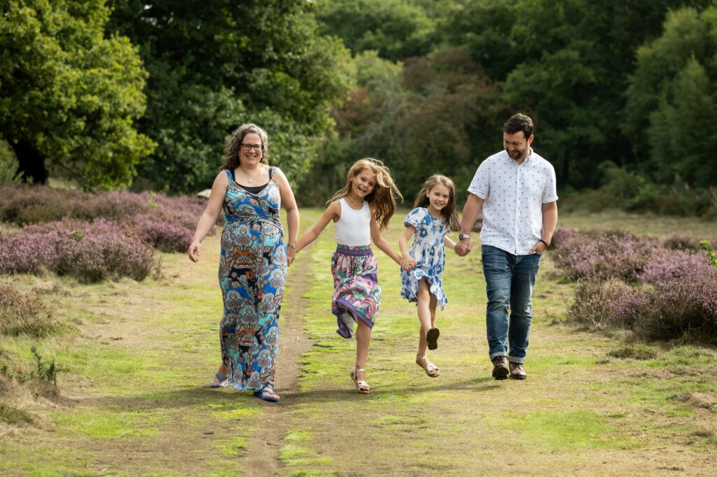 Family walk along with daughters skipping on family photoshoot in St Albans