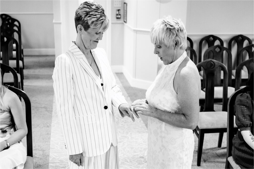 Two brides exchange rings in intimate St Albans Register Office civil partnership ceremony.