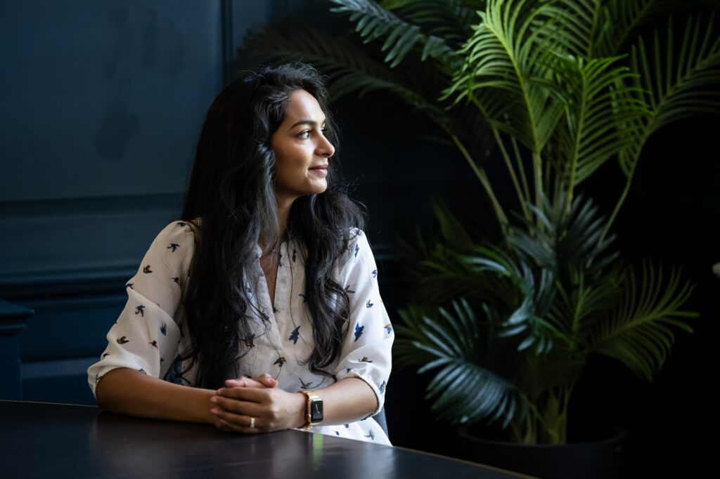 London business woman looks into distance in conference room on branding shoot